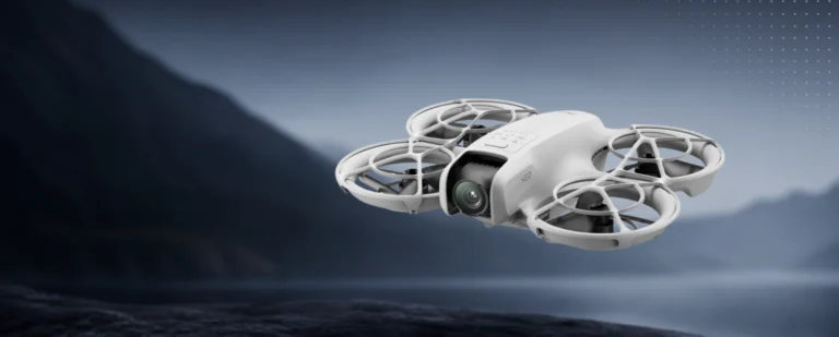 DJI Neo Fly More Combo mini dron u letu iznad mirne obale s liticama u pozadini