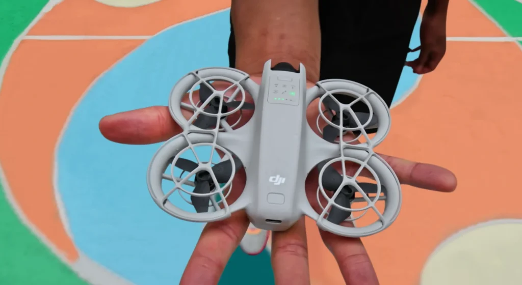 DJI Neo na dlanu prikazuje kompaktne dimenzije i integriranu zaštitu propelera prije polijetanja.