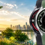 Tri OnePlus Watch 3 - 4 pametna sata u različitim bojama ispred modernog gradskog parka s jezerom tijekom zlatnog izlaska sunca.