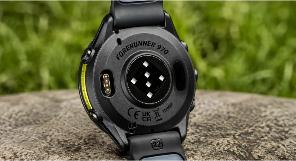 Stražnja strana pametnog sata Garmin Forerunner 970 s optičkim senzorom, kontaktima za punjenje i silikonskom narukvicom.